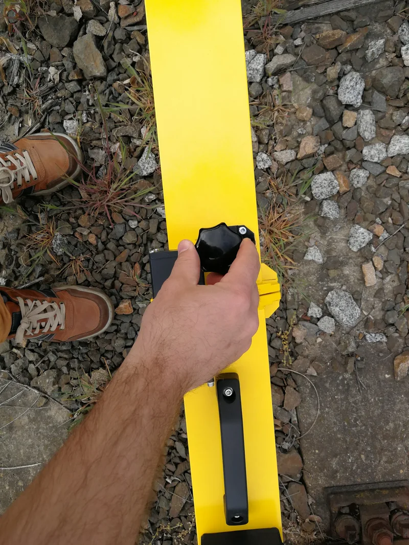 One hand-tightened knob locks the arm to the beam, no tools needed