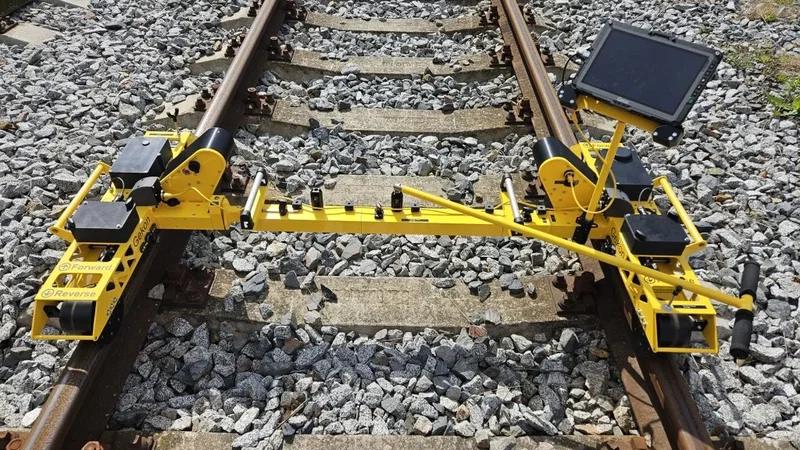 A measuring unit on each rail, joined by the cross beam: corrugation and rail profiles of both rails in one pass, followed on the tablet
