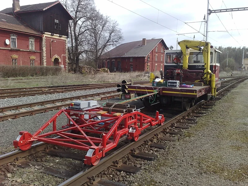 The measuring undercarriage runs ahead of the vehicle that tows it; the cable carries the signals to Krab OnBoard in the cab